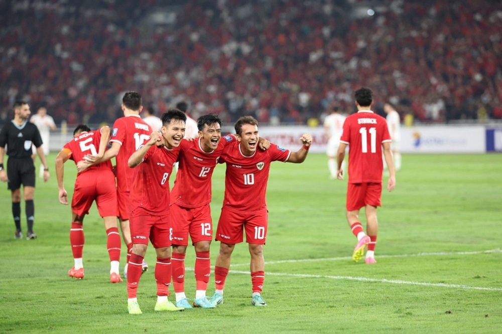 Pemain Timnas Indonesia U-23 merayakan gol dengan jersey merah putih di lapangan sepak bola.