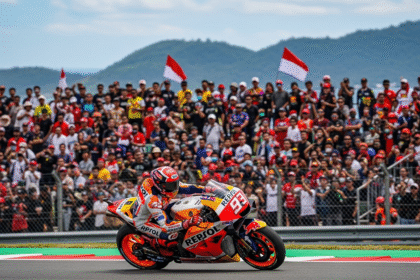 Marc Marquez sedang beraksi dengan kecepatan tinggi di Sirkuit Mandalika, disaksikan oleh para penggemar MotoGP.