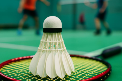 Kok bulutangkis dan raket di lapangan, simbol semangat bulutangkis Indonesia di Macau Open 2025 .