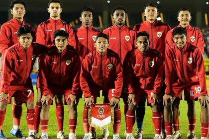 Pemain Timnas Indonesia U-17 berlatih sepak bola di lapangan hijau dengan latar belakang pegunungan dan stadion.